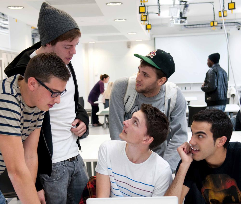 A group of five graphic design students working on a project