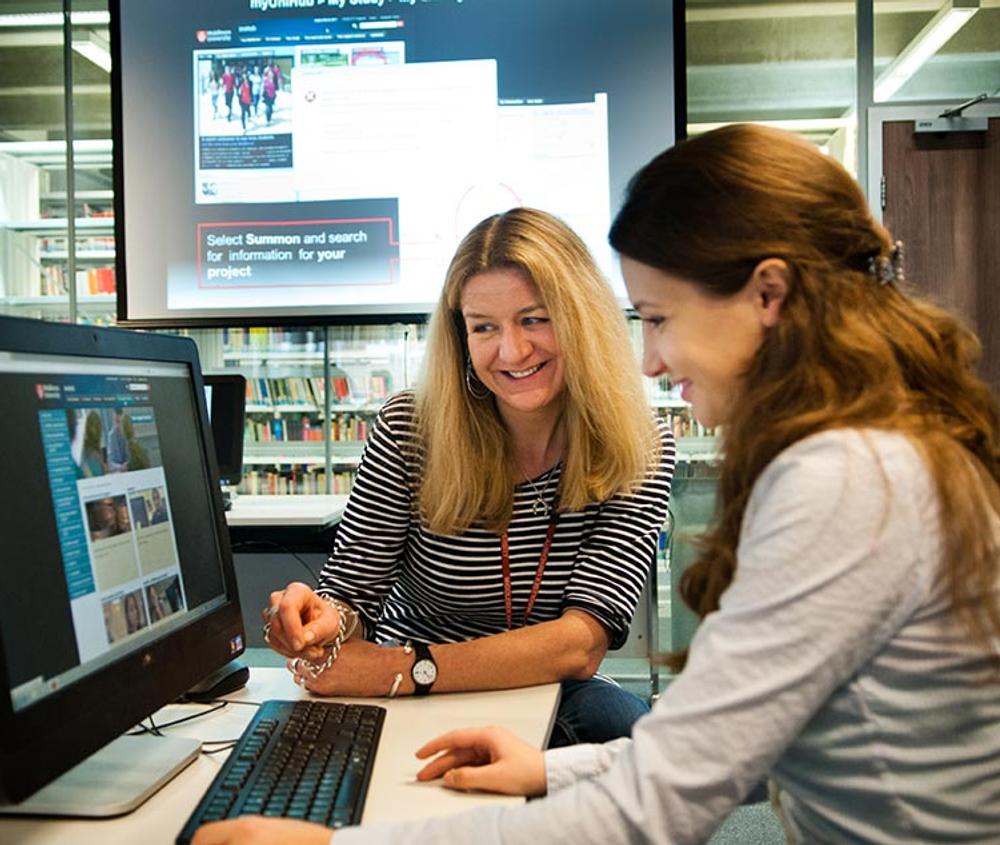 Student using computer help from library support