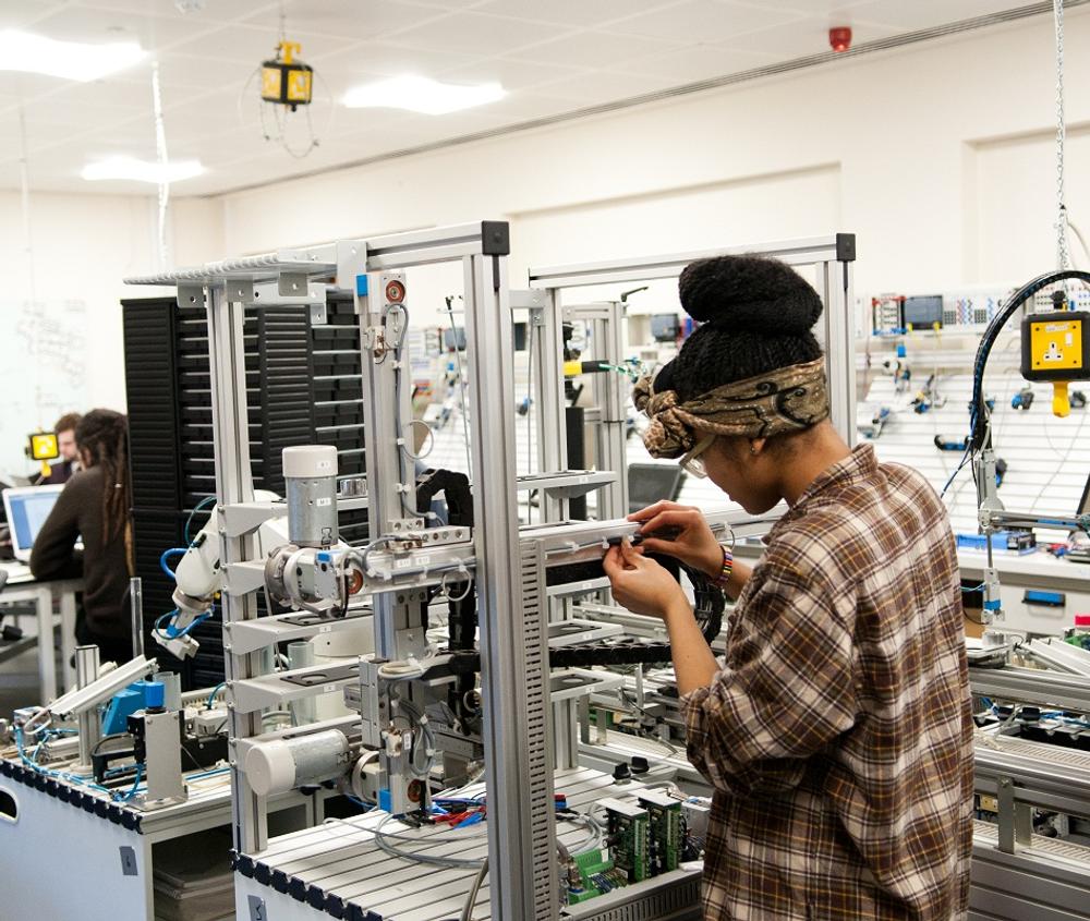 female student works with complex technological equipment