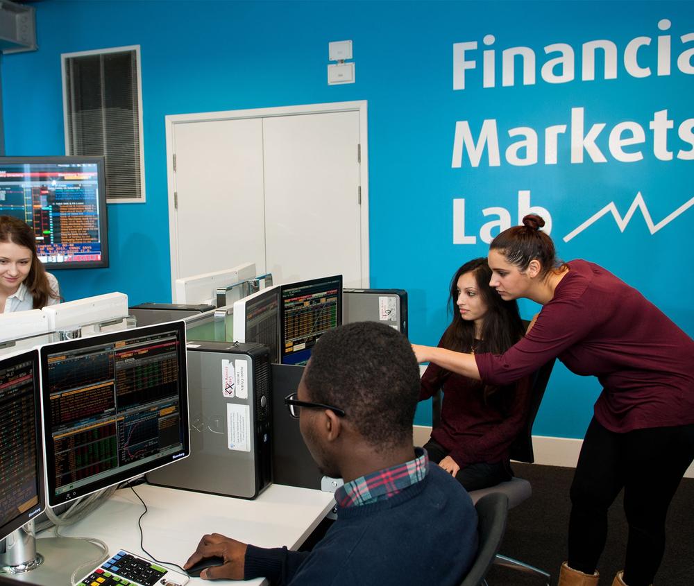 a group of student study financial movements on screens in the financial markets lab at middlesex university