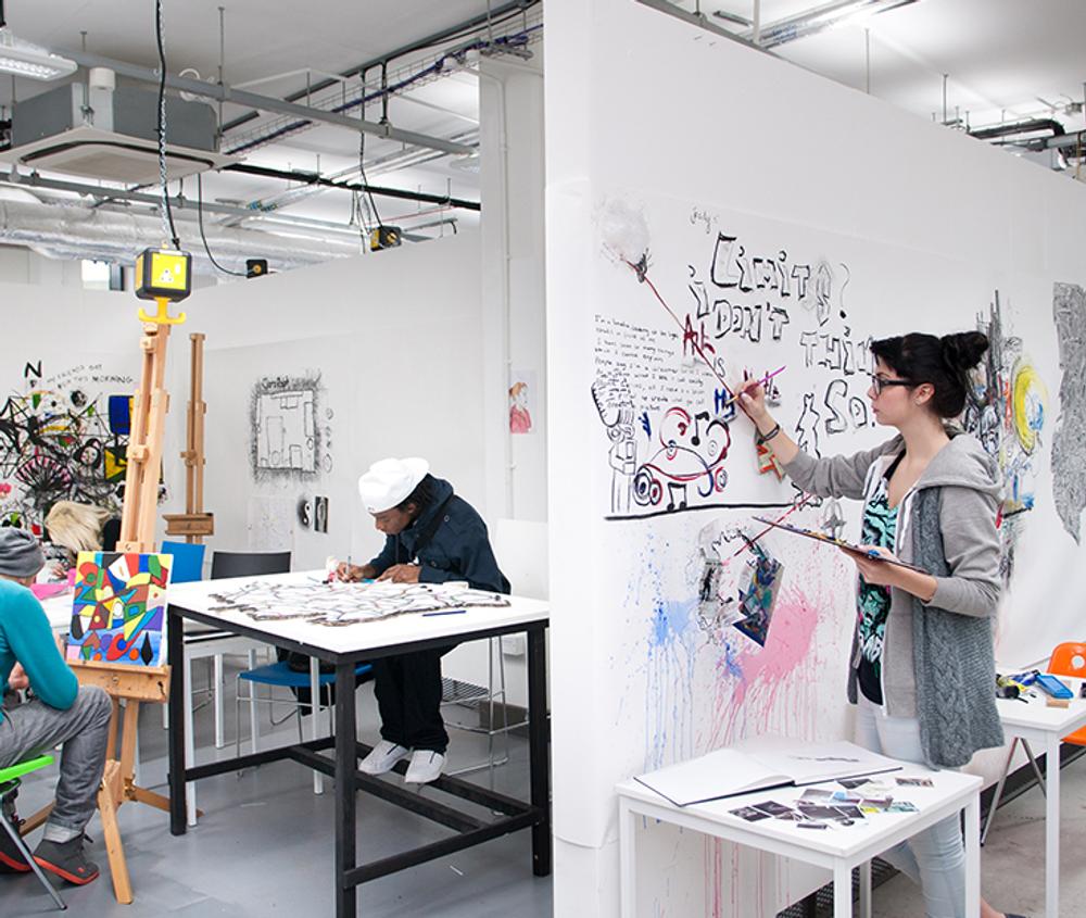 The Fine BA honours art studio with students drawing and painting on canvases and white walls