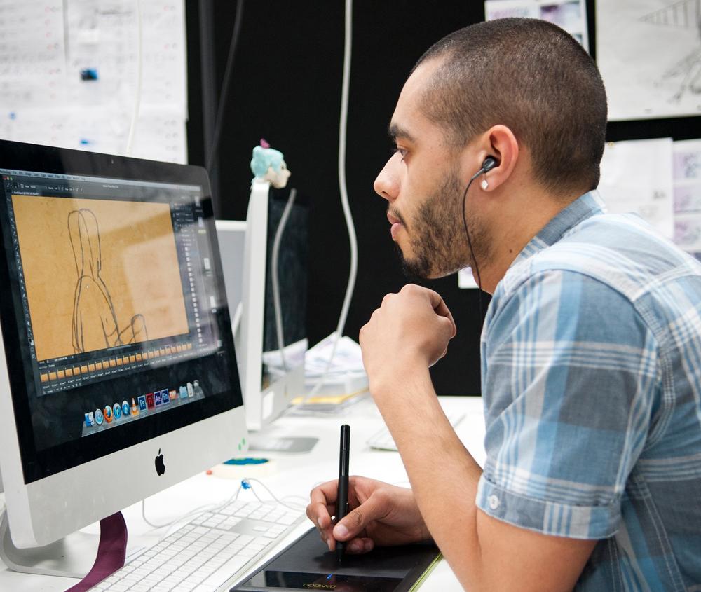 A student working on an animation project with an Apple Mac and stylus