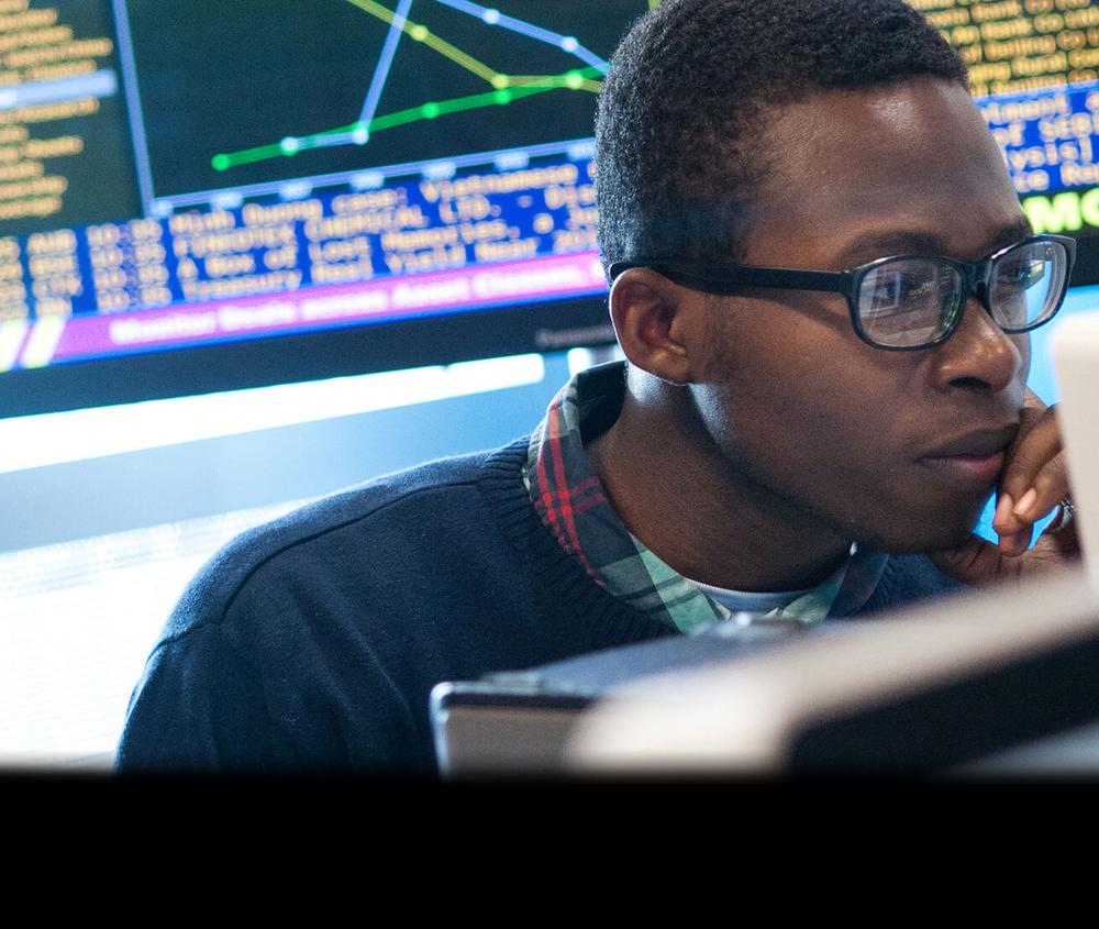 Student with glasses focusing on computer screen