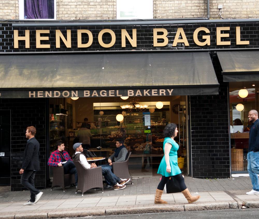 People walking by the Hendon Bagel Bakery in London