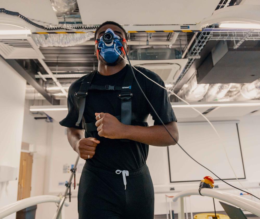 A sports student running with a mask on to analyse performance