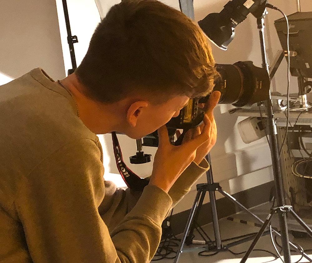 Student taking photo in photography studio