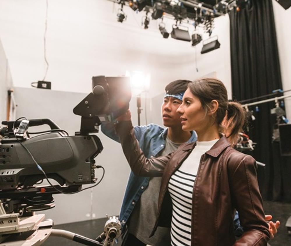 Two students examining a film camera