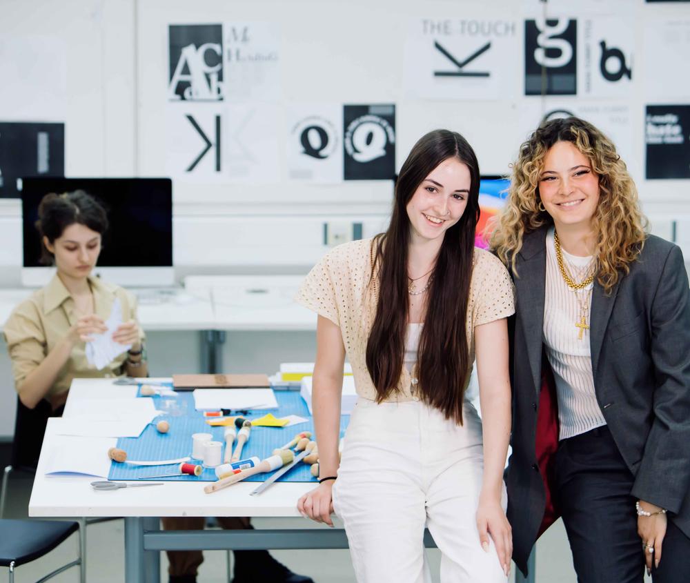 Two graphic design students smiling at the camera