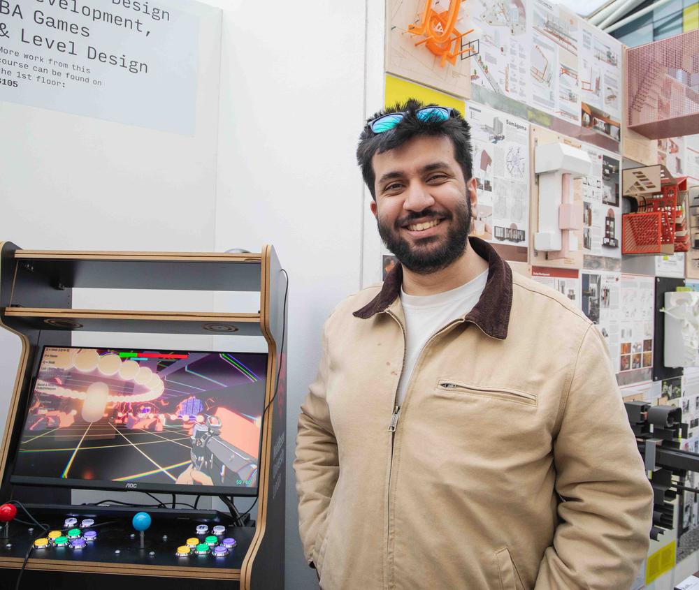 An artist poses in front of his work at an art exhibition