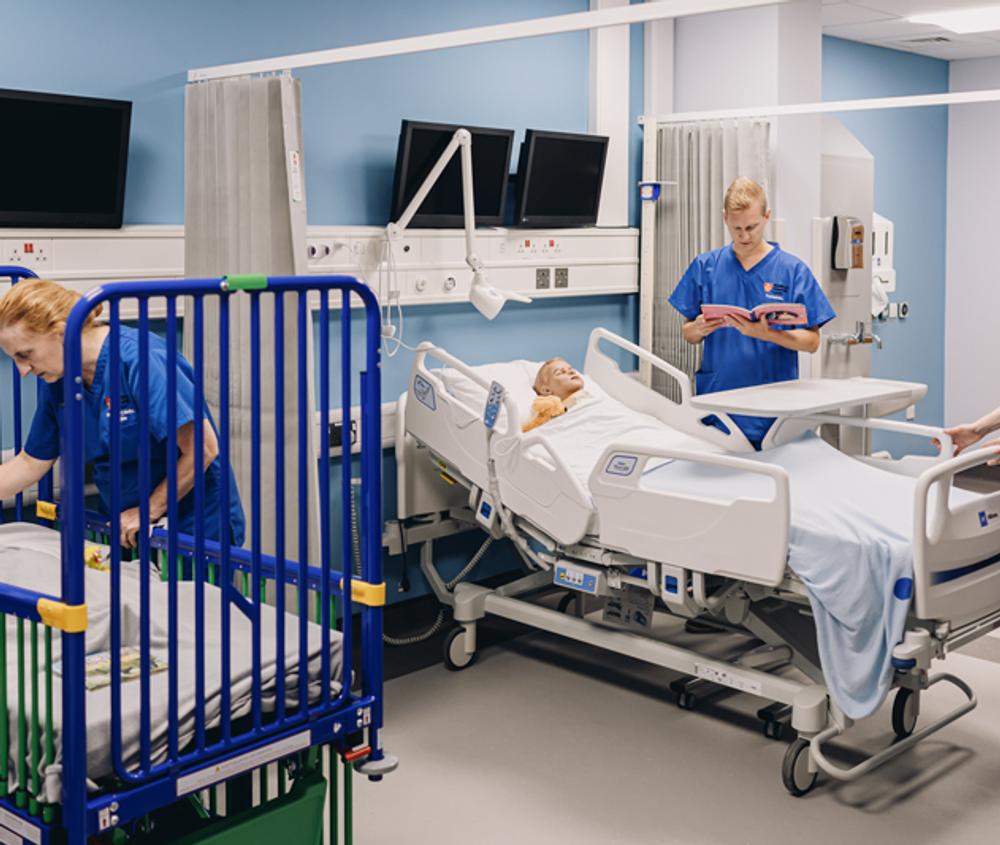 Medical staff dressed in scrubs train in a simulated children's hospital ward