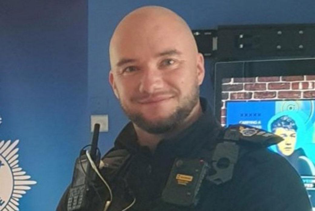 A police officer looks at the camera