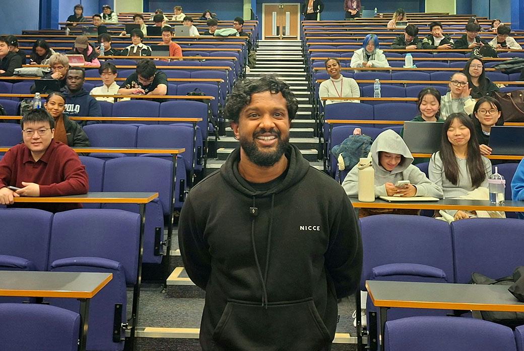 A man stands in a lecture theatre