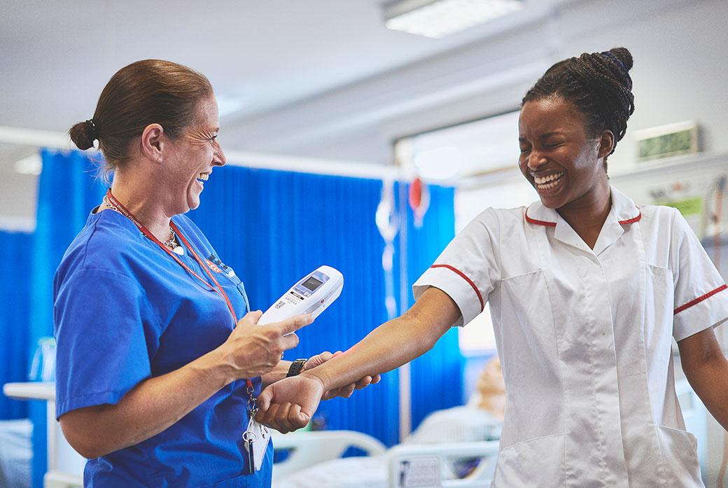 Nurses share a joke as they do a test on the ward