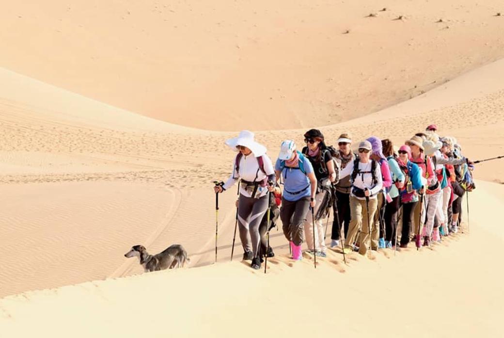 Group on people walking on a sand dune