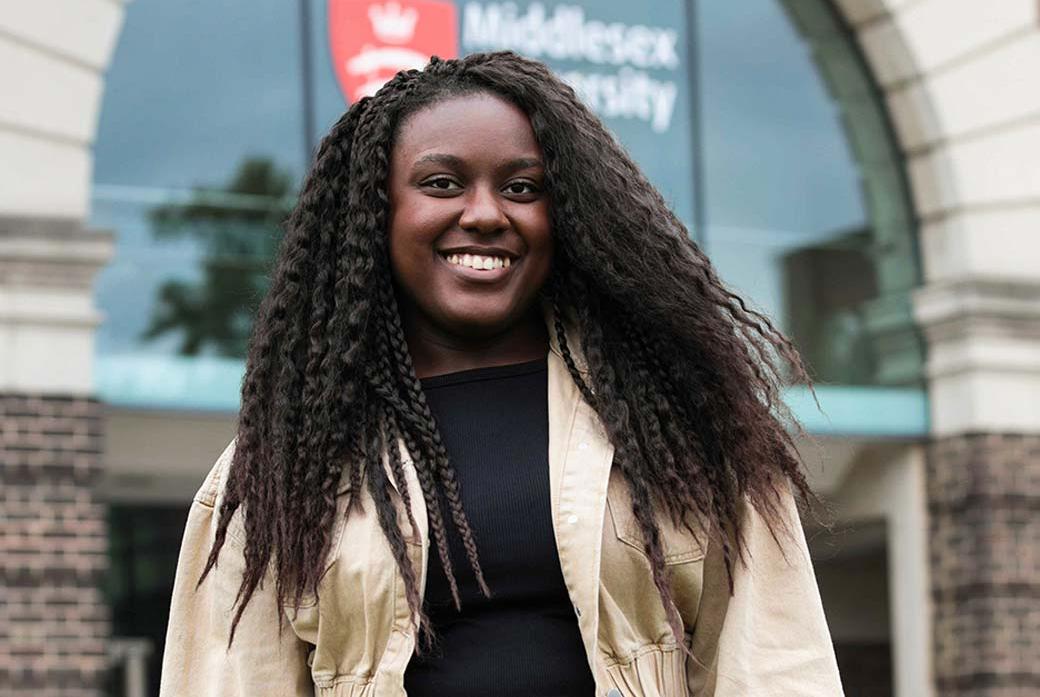 Student with curly long hair smiling at the camera