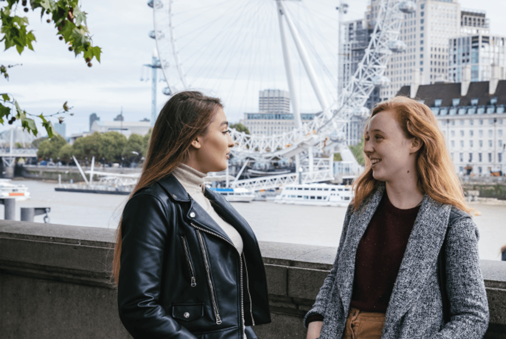 students by the river Thames, next to Westminster Bridge, London eye in the background