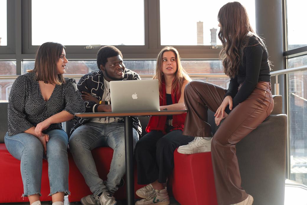 A group of postgraduate students chatting on sofa