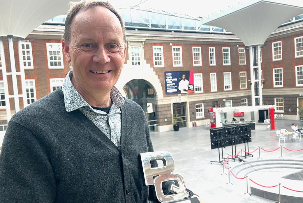 A man with an award in an atrium