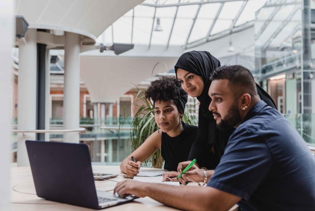 Business management students working on a computer at the quad