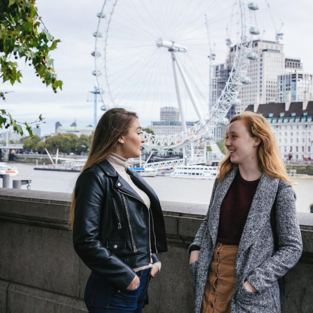 students by the river Thames, next to Westminster Bridge, London eye in the background