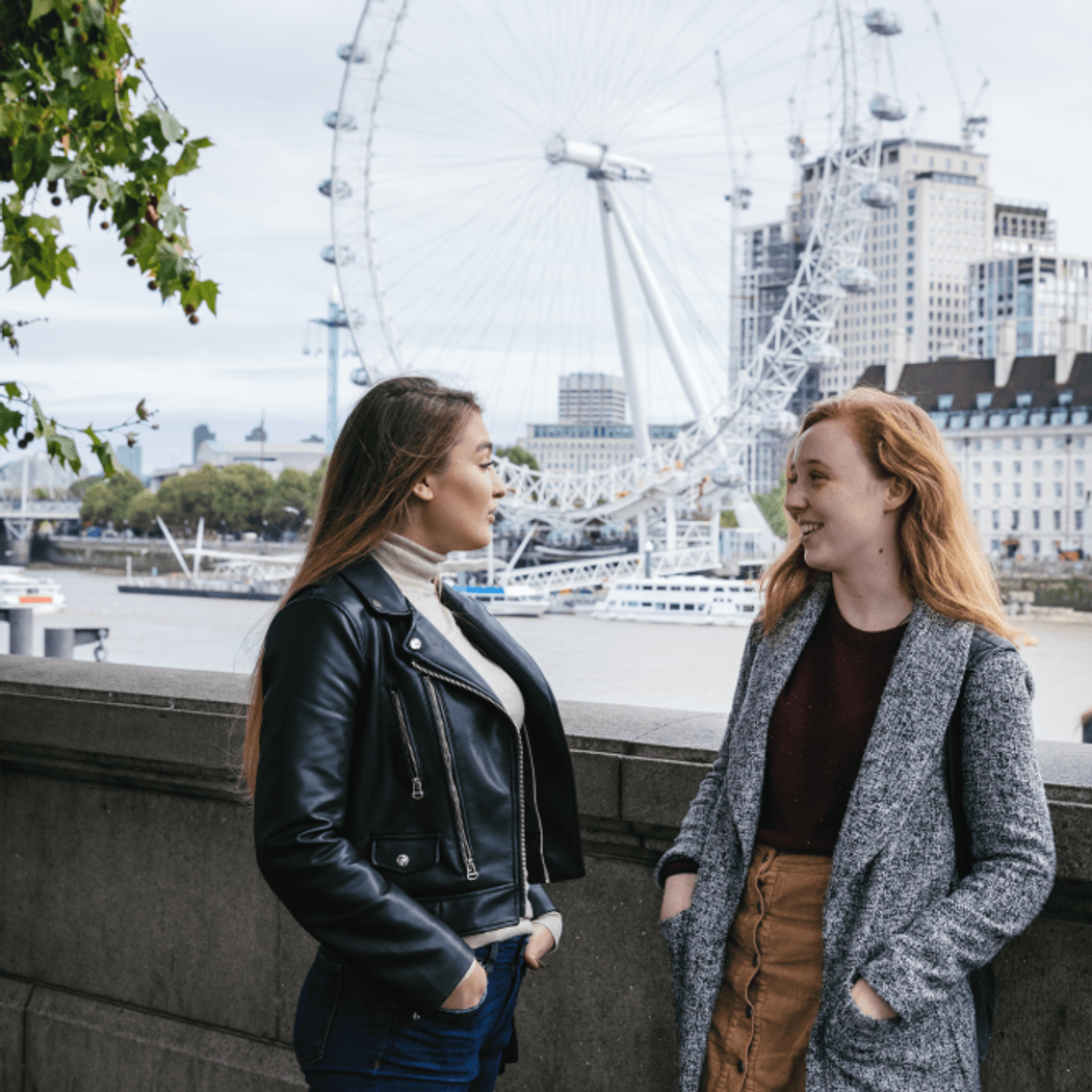 students by the river Thames, next to Westminster Bridge, London eye in the background
