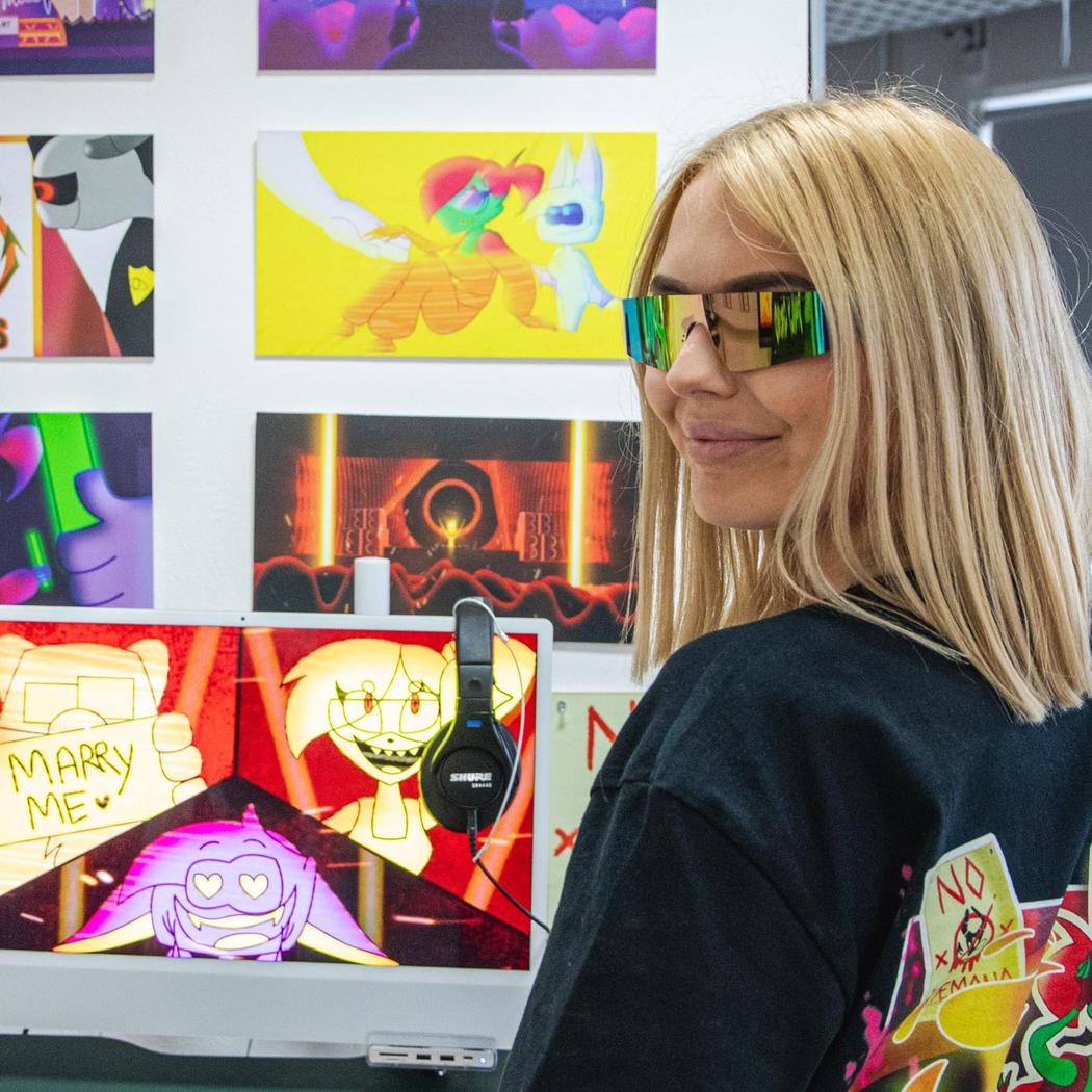 Middlesex student wearing glasses showcasing their work on the degree show
