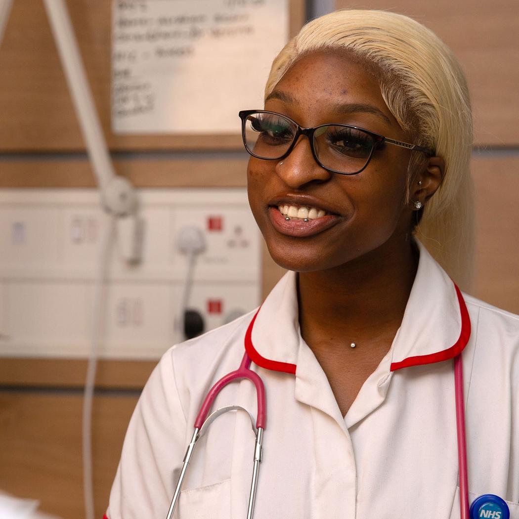 A smiling black female Nursing student smiling at another student