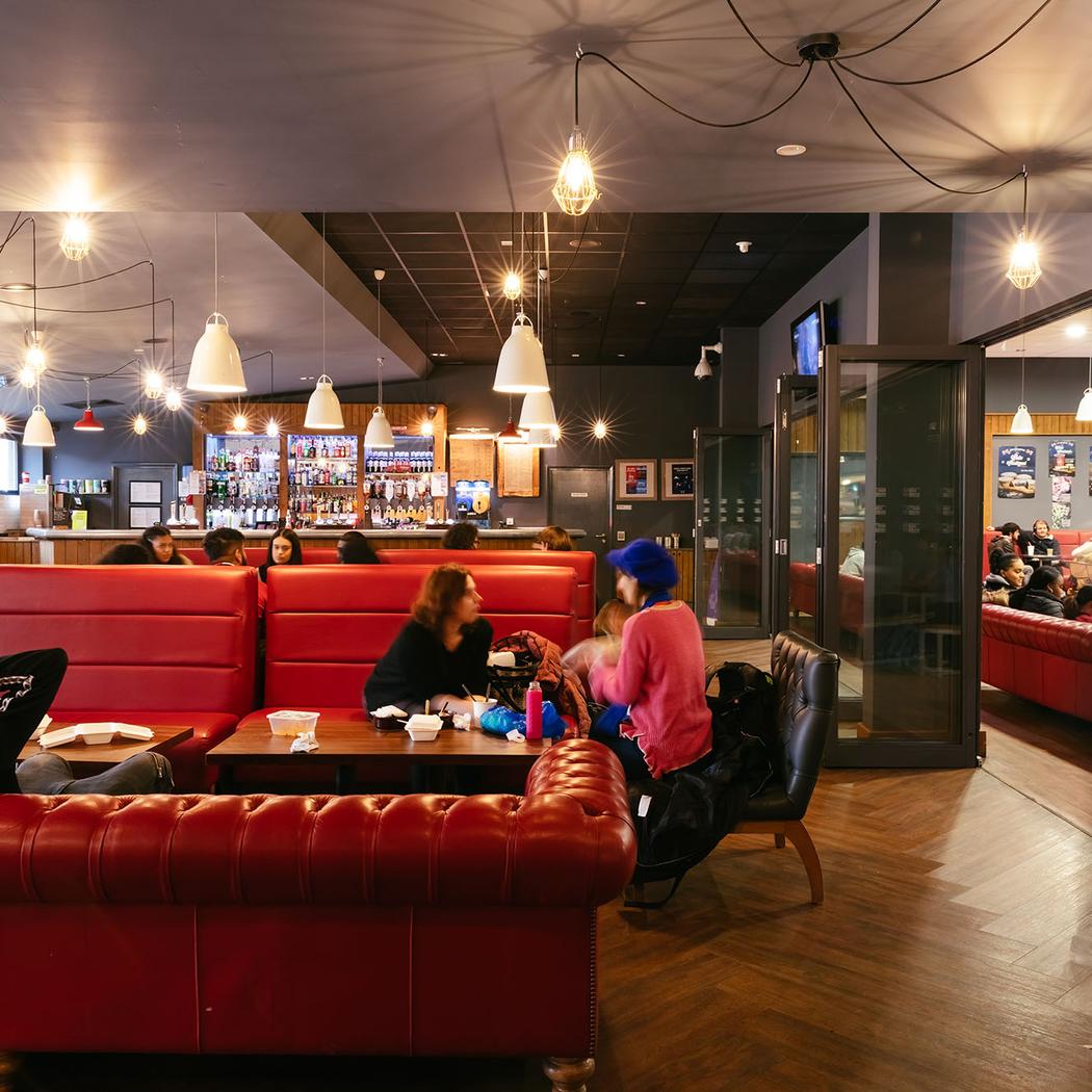 Image of bar/cafe social space with red sofas