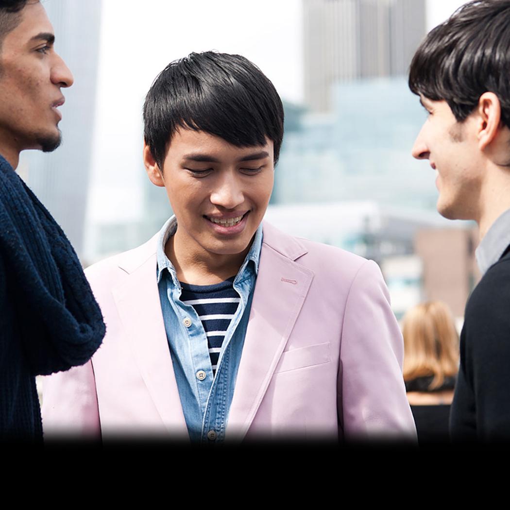 three students facing each other smiling
