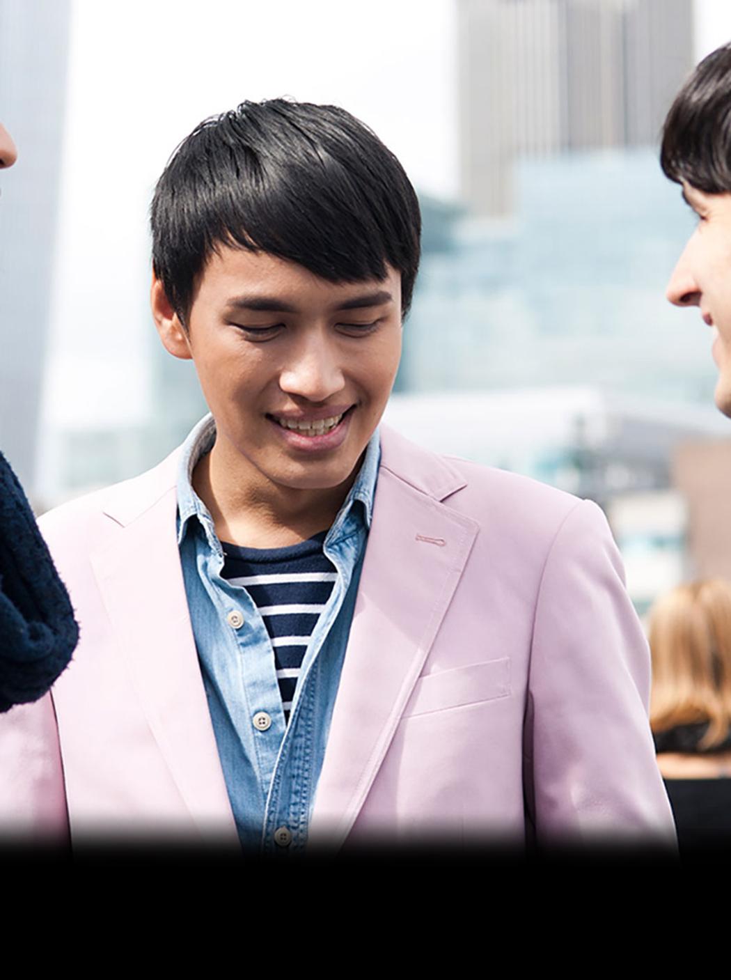 three students facing each other smiling