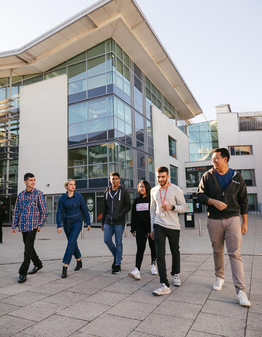 6 students walk in front of the sheppard library on middlesex university campus hendon