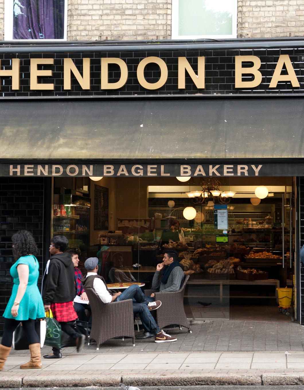 Fresh bagels and a cup of coffee on a wooden table at a local bakery.