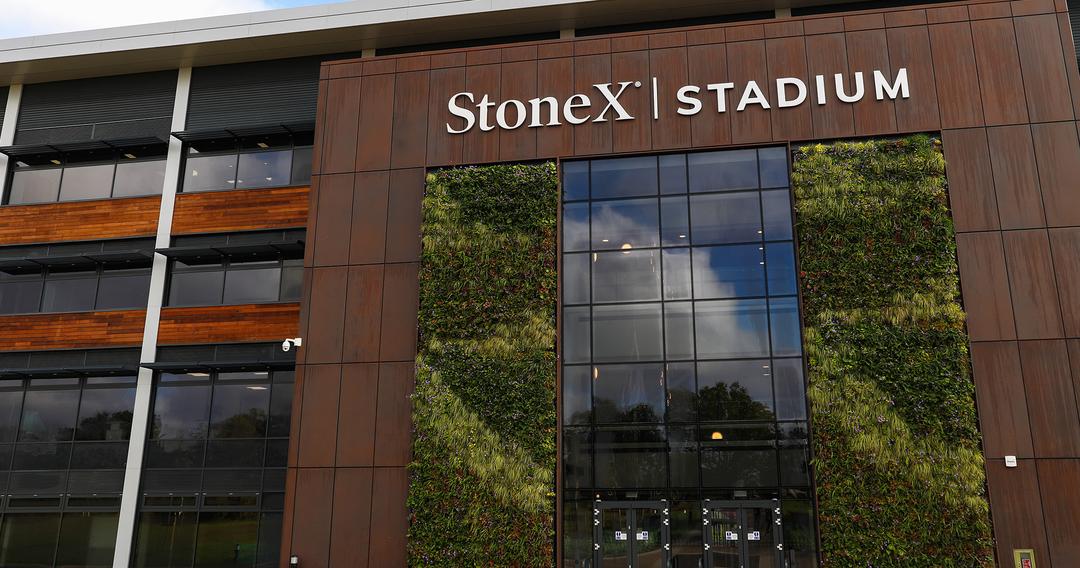 outside of a large stadium with climbing plants, large letters on stadium say StoneX Stadium