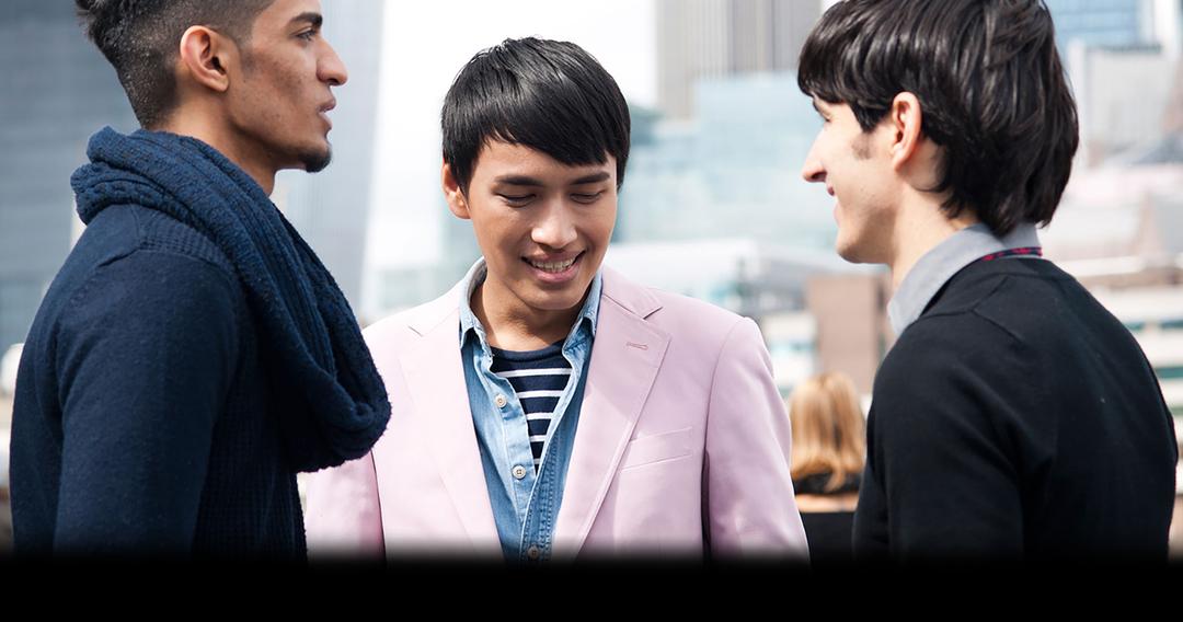 three students facing each other smiling