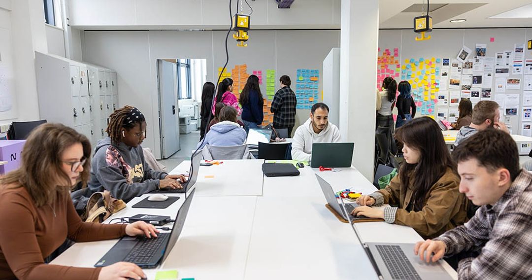 Graphic design students working around desk