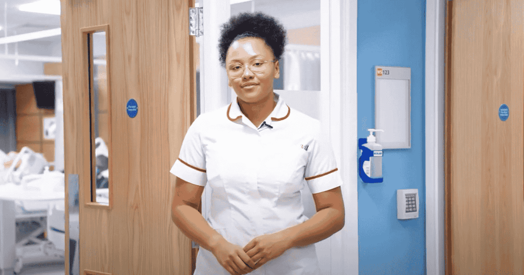 A nurse standing a hospital corridor talking in a video
