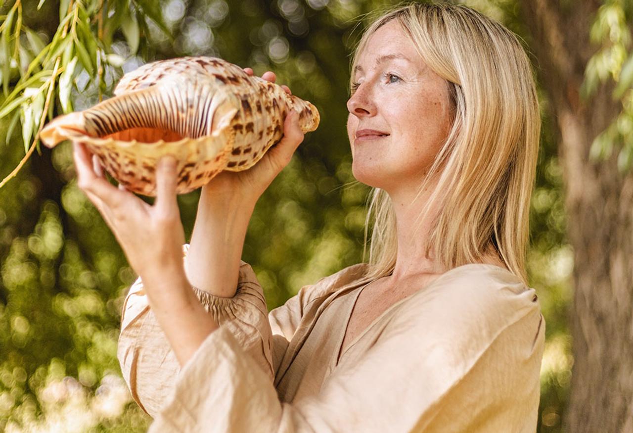 Woman plays ancient shell trumpet