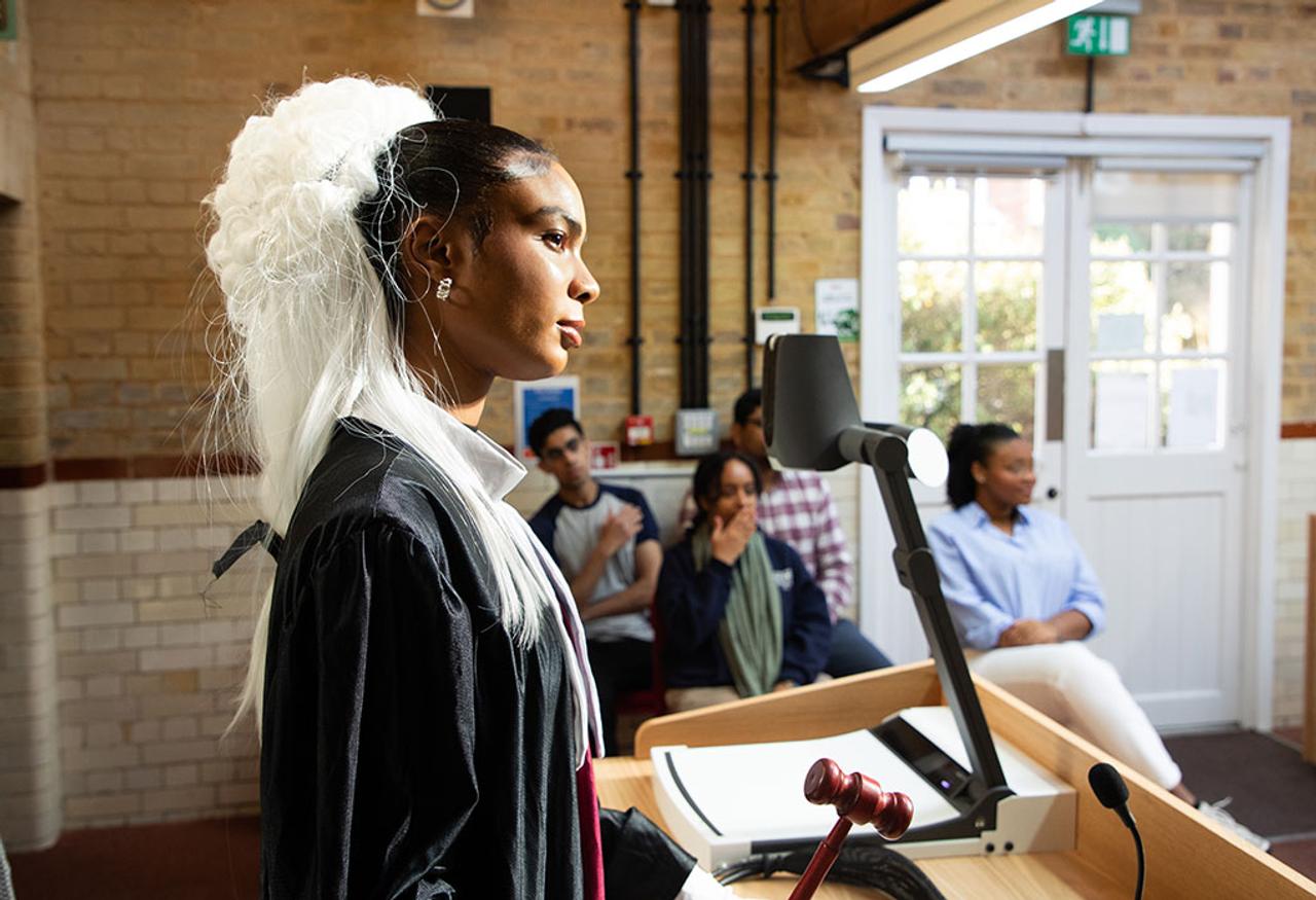 A judge listens in a mock student courtroom