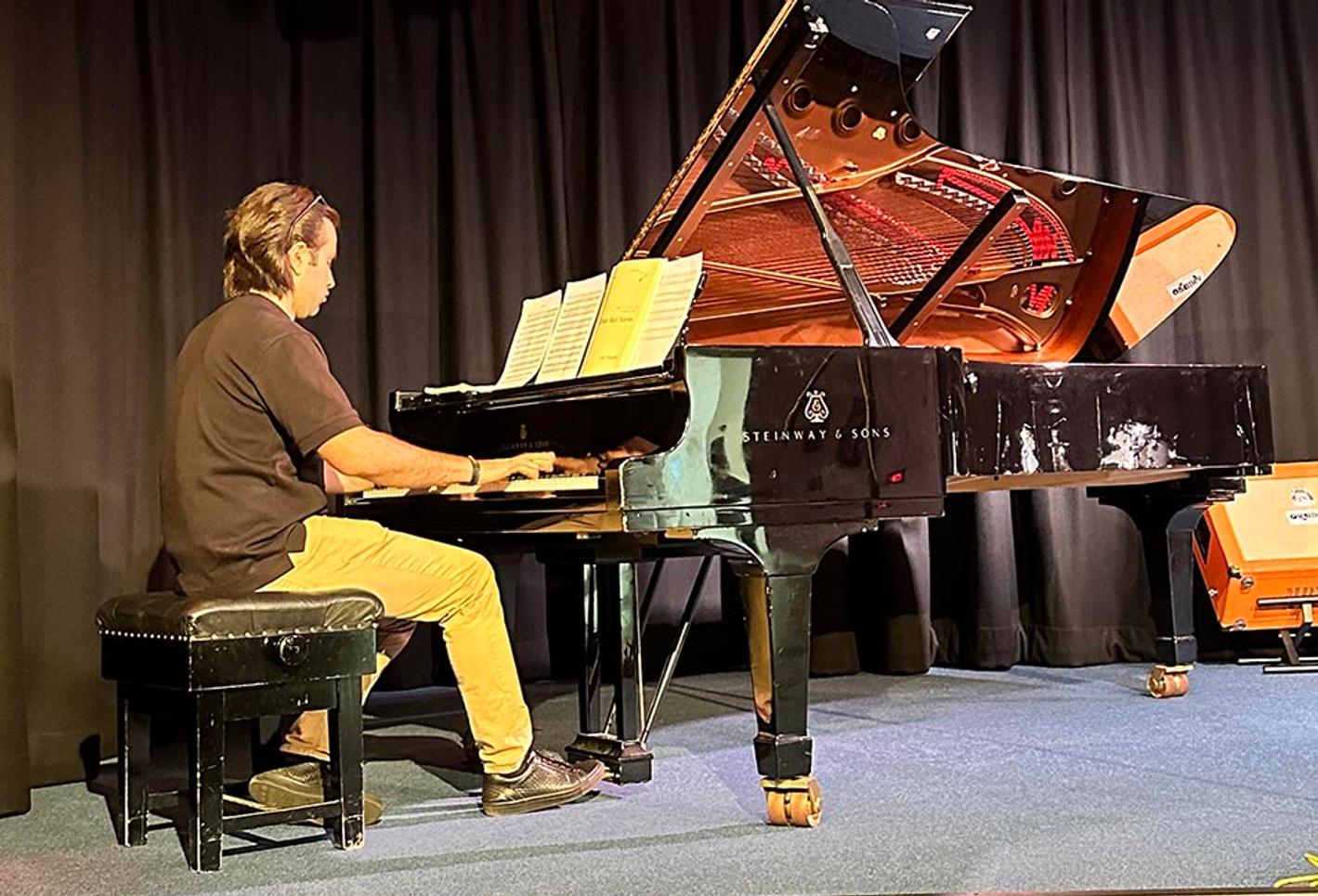 Man on stage playing a piano