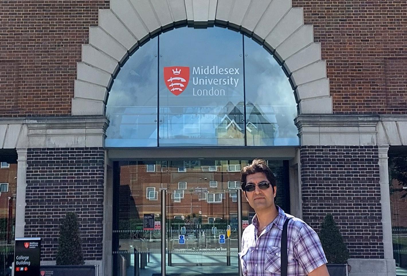 Saeed Ahmadi standing outside the entrance to Middlesex University.