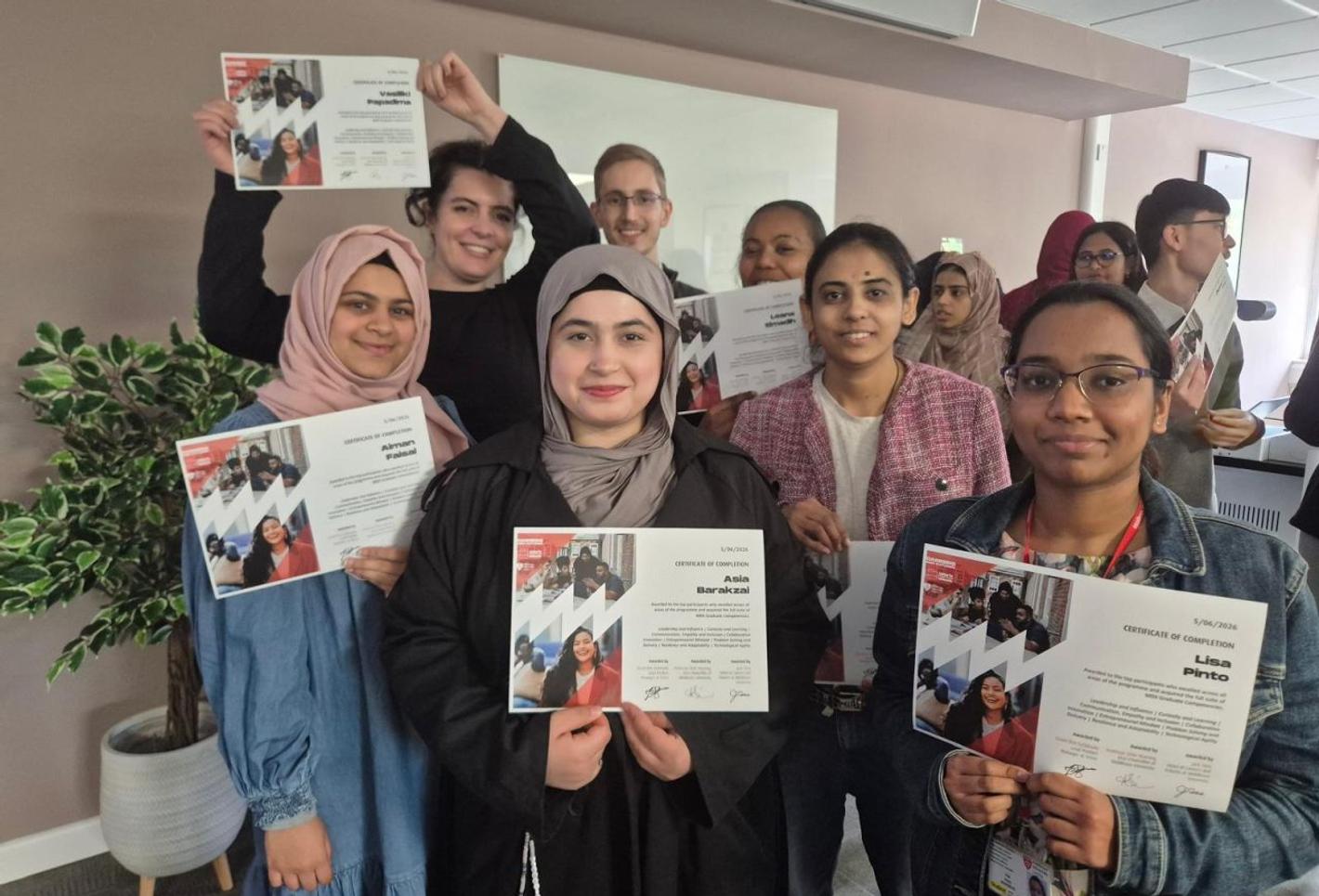 A diverse group of students proudly holding certificates after completing a work experience week at Middlesex University. The programme focused on employability skills, workplace experience, professional development, and career preparation.