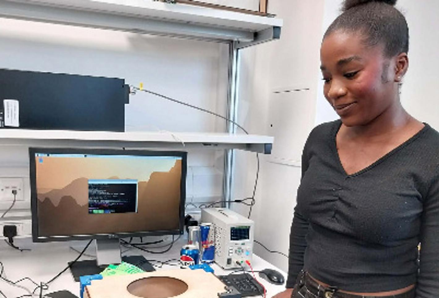 A woman in an engineering lab looks at a piece of equipment