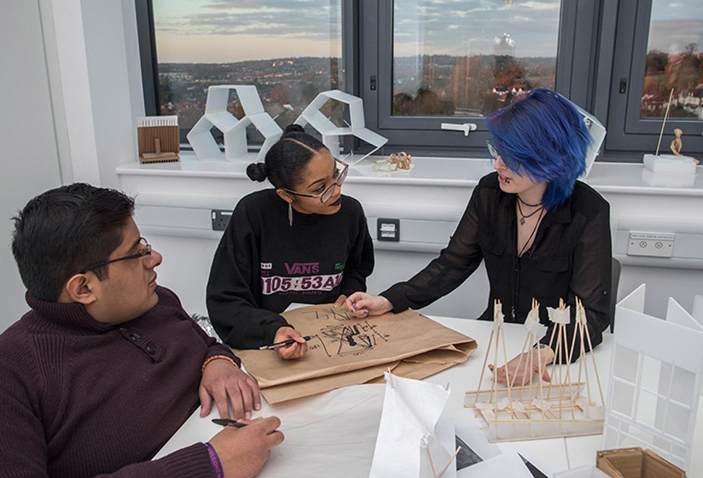 Young students looking at interior architecture design sketches