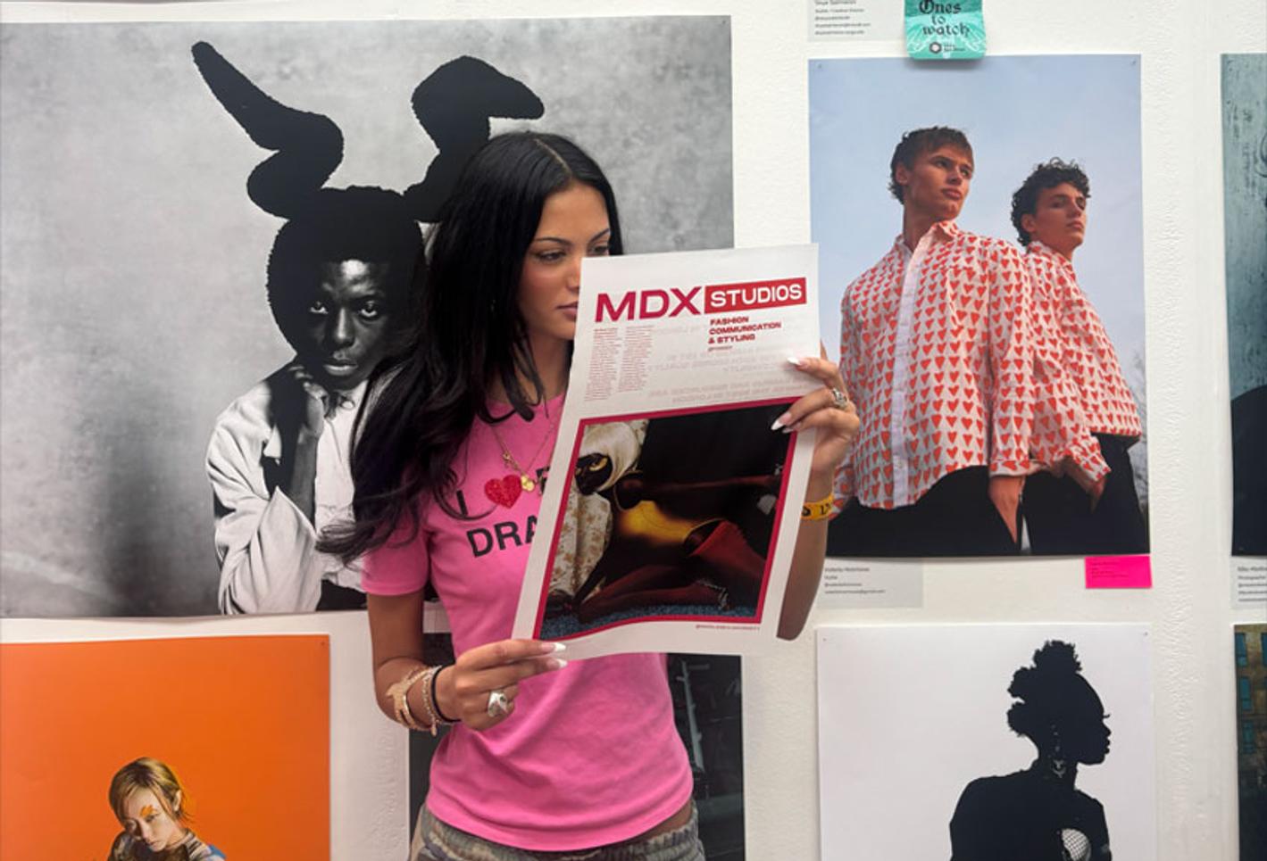 Creative student standing with work at exhibition