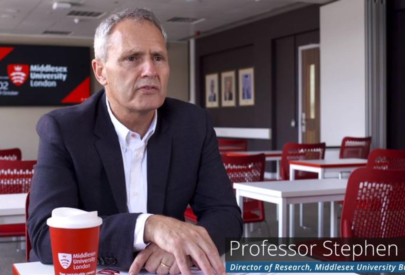 A male professor in a classroom setting having an interview