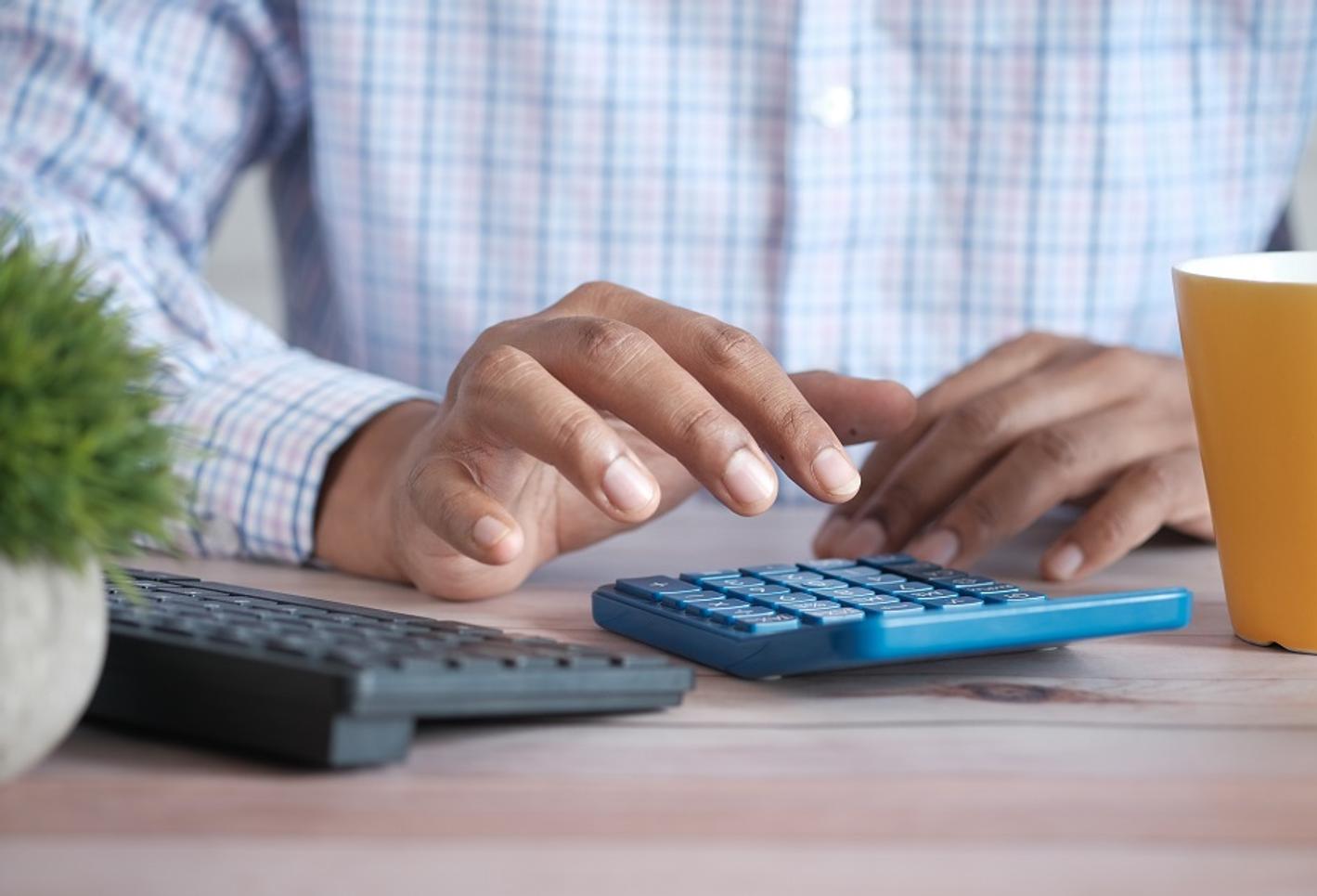 Man typing on a calculator