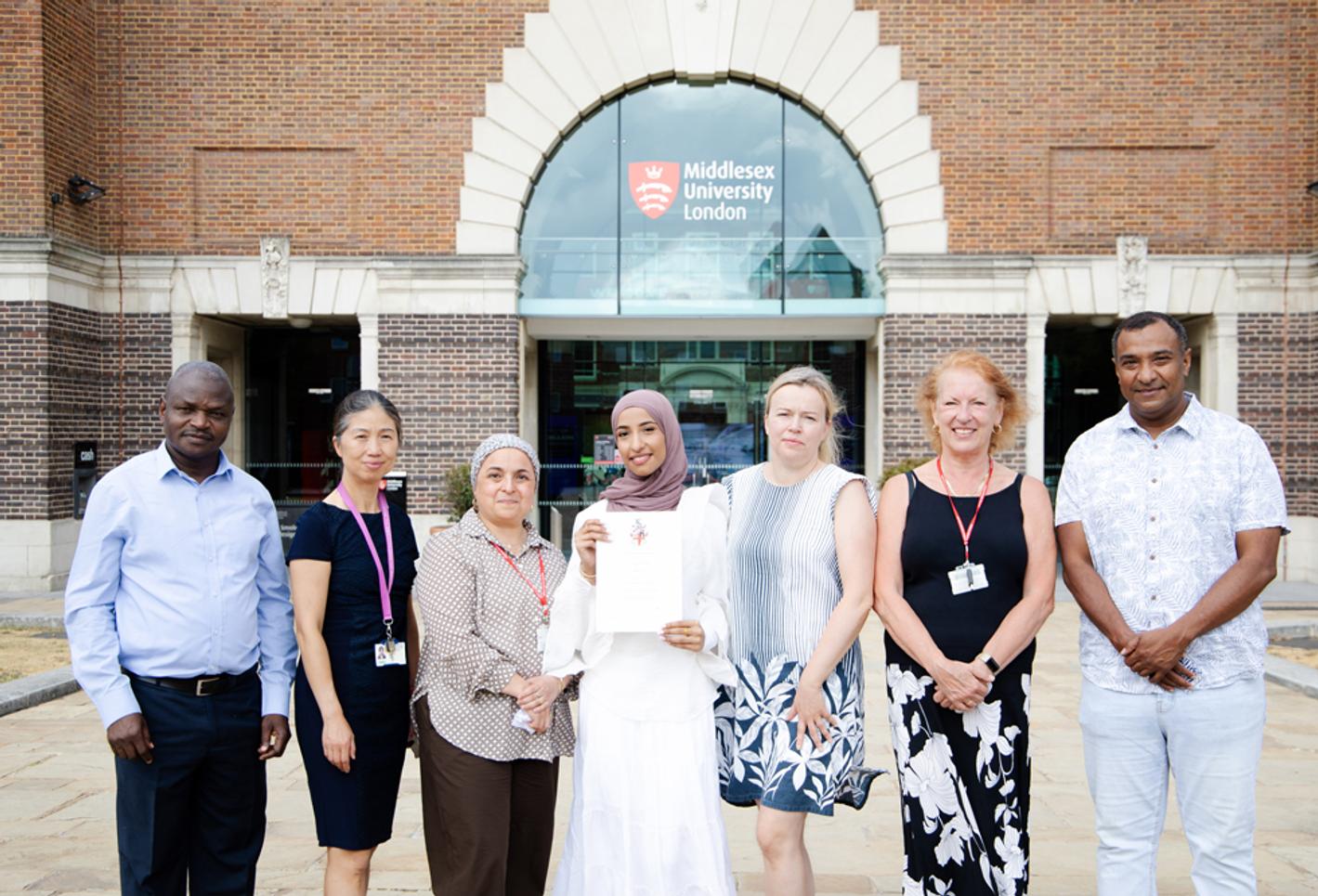 Biomedical science student standing out the front of Middlesex campus with course lecturers