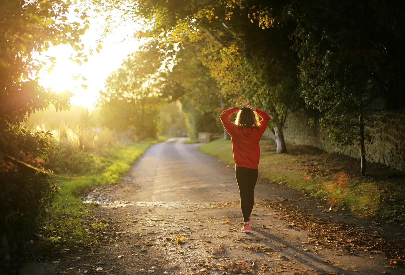 A woman is walking along a track in the park.