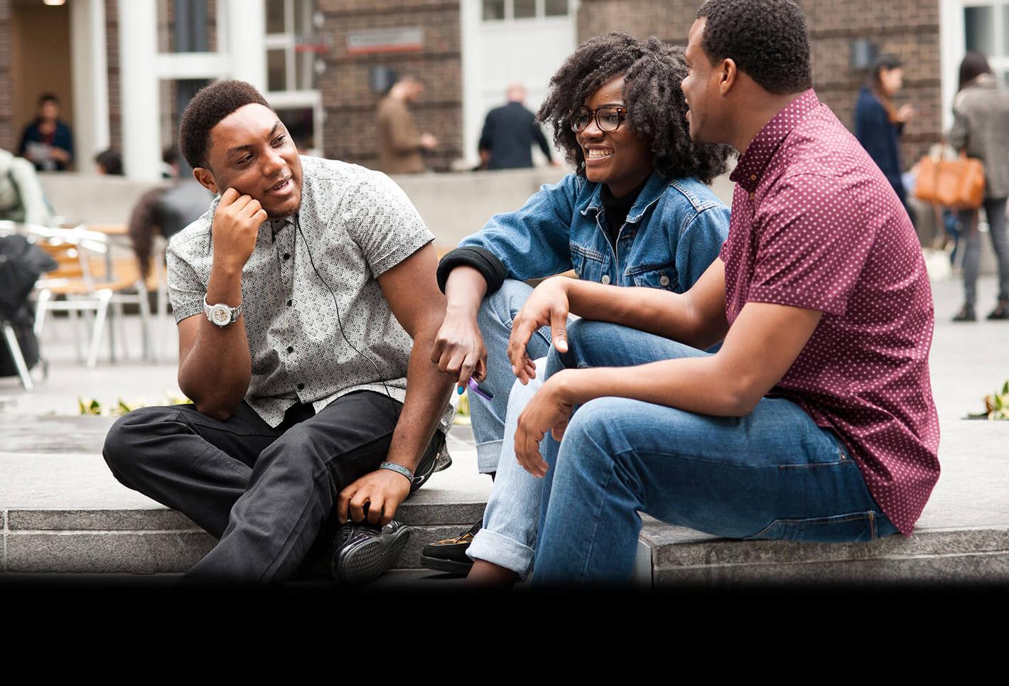 a group of middlesex university students sit and chat in the quad