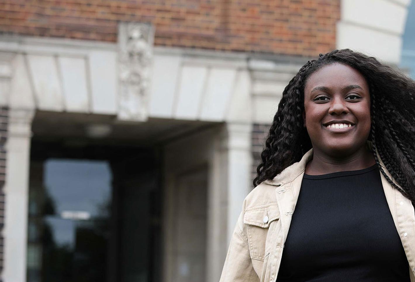 Peace - clearing student stood in front of gallery of work